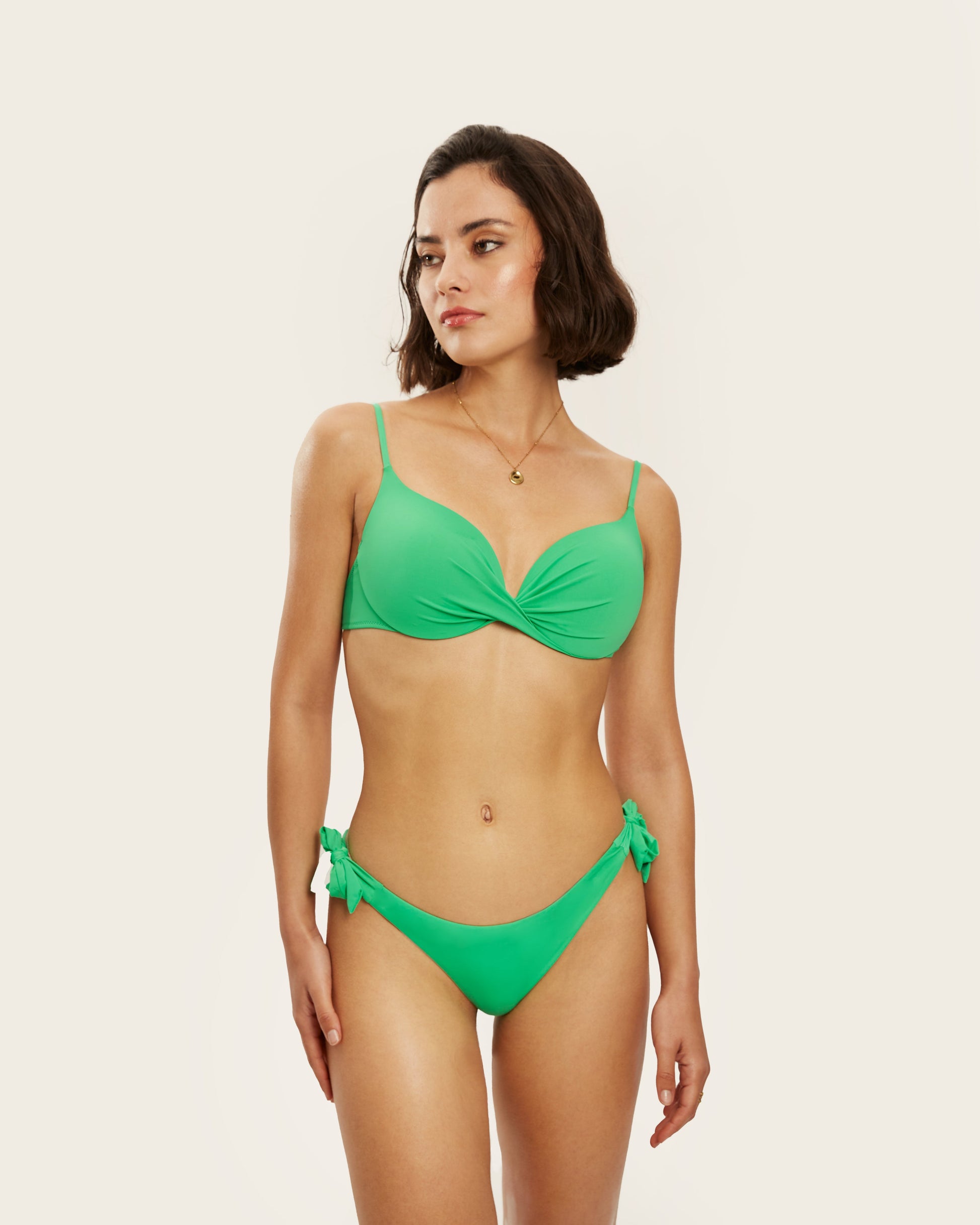 Bikini de dos piezas en color verde brillante con top cruzado y braguita con lazos ajustables